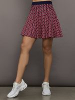 Model wears a red and blue patterned pleated high waisted tennis skirt.
