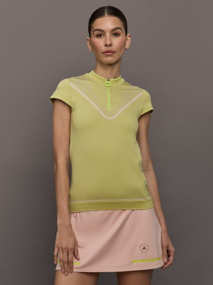 Model wears a short sleeve zip up activewear yellow/gold polo.