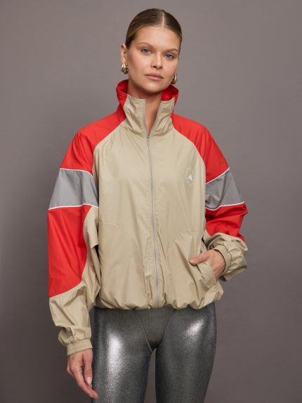 Model is wearing red, grey, and gold track jacket