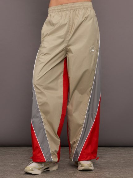 Model is wearing red, grey, and gold track pants.