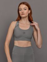 Model wears grey sports bra with a racerback design, mesh panels, and small laser-cut holes.