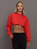 Model wears red cropped sweatshirt with a loose fit, ribbed edges, and a back cut-out detail.