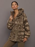 Woman wearing a patterned jacket against a gray background