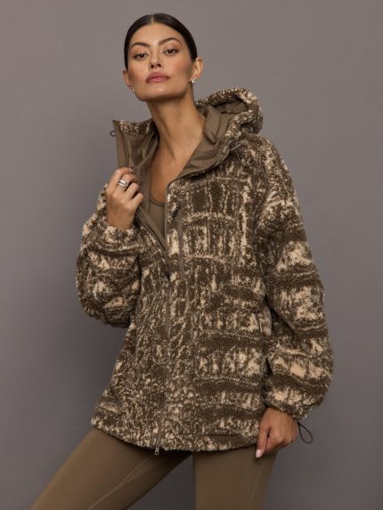 Woman wearing a patterned jacket against a gray background