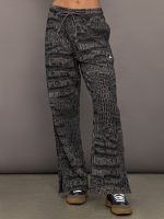 Model wears charcoal patterned sweatpants.