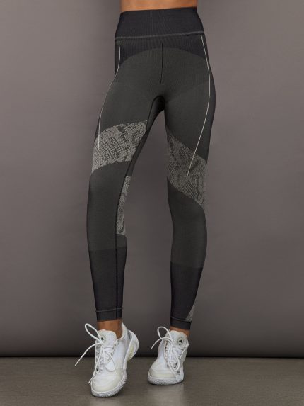 Person wearing black and gray leggings with a patterned snakeskin design on a gray background
