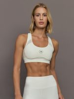 Model wearing a white sports bra with Adidas logo.
