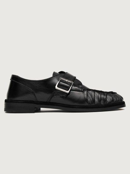 Black leather dress shoe with a buckle.