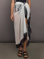 Model wears balmain print skirt with a long, flowy silhouette and a tie closure at the waist.