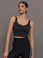 Model wears a black vneck cropped tank top.