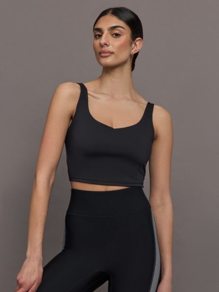 Model wears a black vneck cropped tank top. 