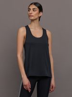Model wears a scoopneck black tank top with racerback silhouette back.