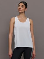 Model wears a scoopneck white tank top.
