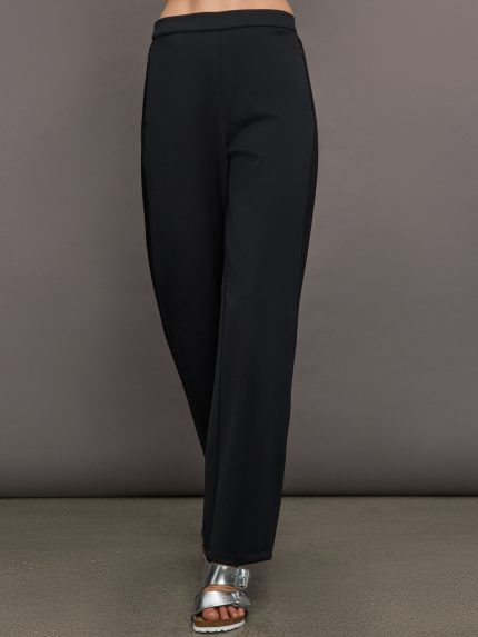 Model wears black wide leg pants with an elastic waistband.