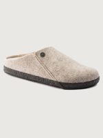 Beige slipper with a black sole on a light gray background