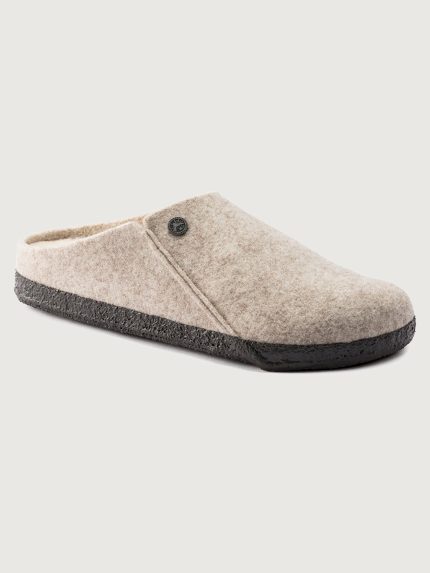 Beige slipper with a black sole on a light gray background