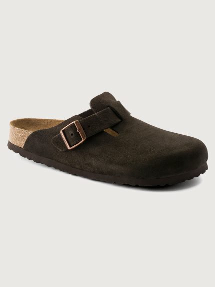 Brown clog shoe with a bronze buckle on a light gray background