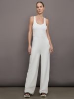 Model wears a white wide leg jumpsuit.