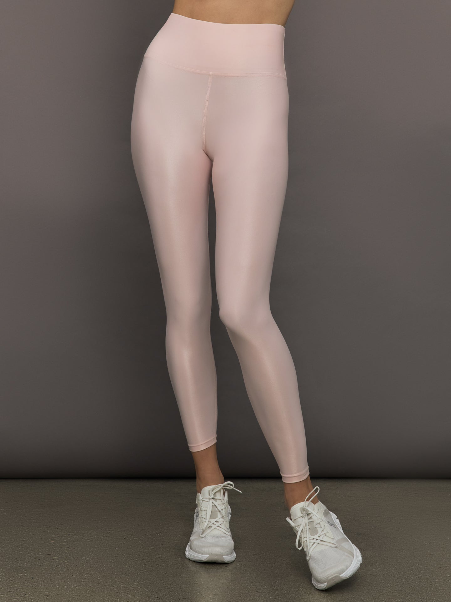 CARB-CRB19051-LOTUS-25SM-High-Rise-7-8-Legging-in-Takara-Shine-color-Lotus_33621-Edit Model wears a pair of high rise baby pink sleek liquidy shine leggings.