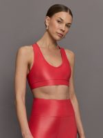 Model wears a v neck bright red bra in a liquidy takara shine finish.