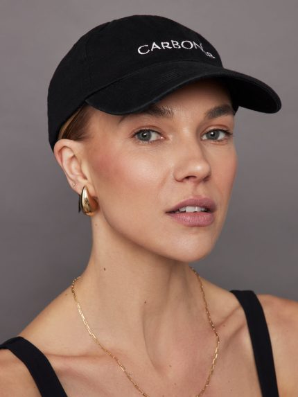 Model wears black baseball cap with the brand name 'CARBON38' on the front.