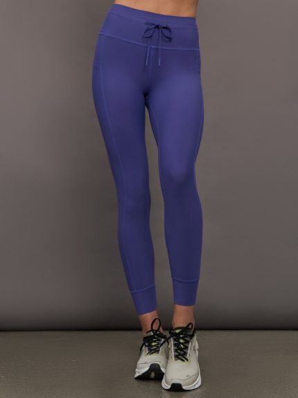 Model wears blue leggings with a high rise and pockets.