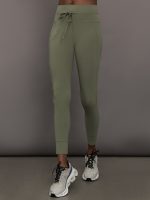Model wears a pair of high waisted leggings in army green olive with a drawstring at waist.