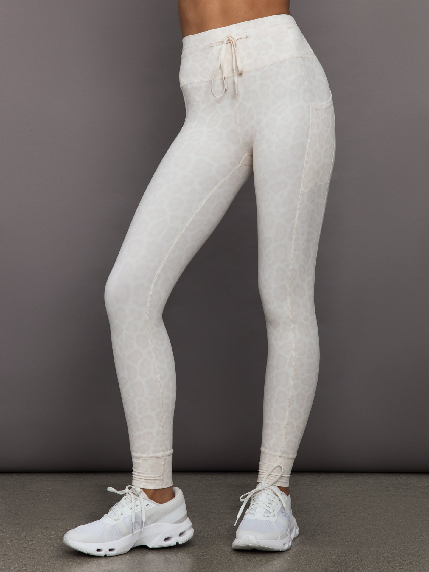 CARB-YD1008LP-SNOWLEO-25FAL-High-Rise-Sport-Pocket-Legging-in-Melt-color-Snow-Leopard_37663-Edit Model wears high-rise sport leggings in snow leopard, featuring side pockets, a wide supportive waistband.