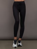 Model wears ribbed black leggings with pockets.