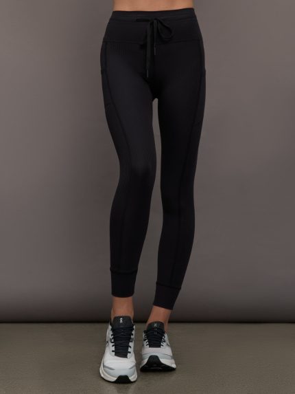 Model wears ribbed black leggings with pockets.