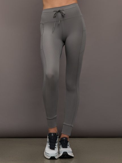 Model wears ribbed steel grey leggings with pockets.