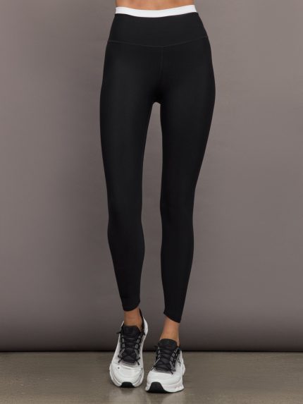 Model wears black full-length leggings with a high-rise, wide waistband with a contrasting white.