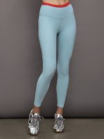 Model wears a light blue performance legging with a red waistline.