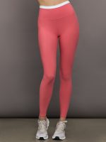 Model wears a buttery soft high waisted rosewood legging with thin white waistband.