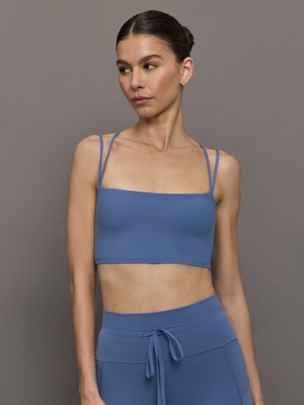 Model wears a periwinkle blue buttery soft cropped sports bra with double straps and a cross back.