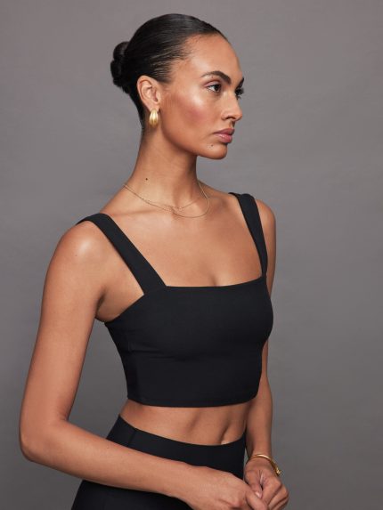 Model wearing a black square neck bra top with thick straps.
