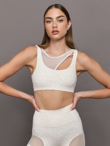 Model wears Snow leopard sports bra with a white mesh overlay, featuring a scoop neckline, wide straps.