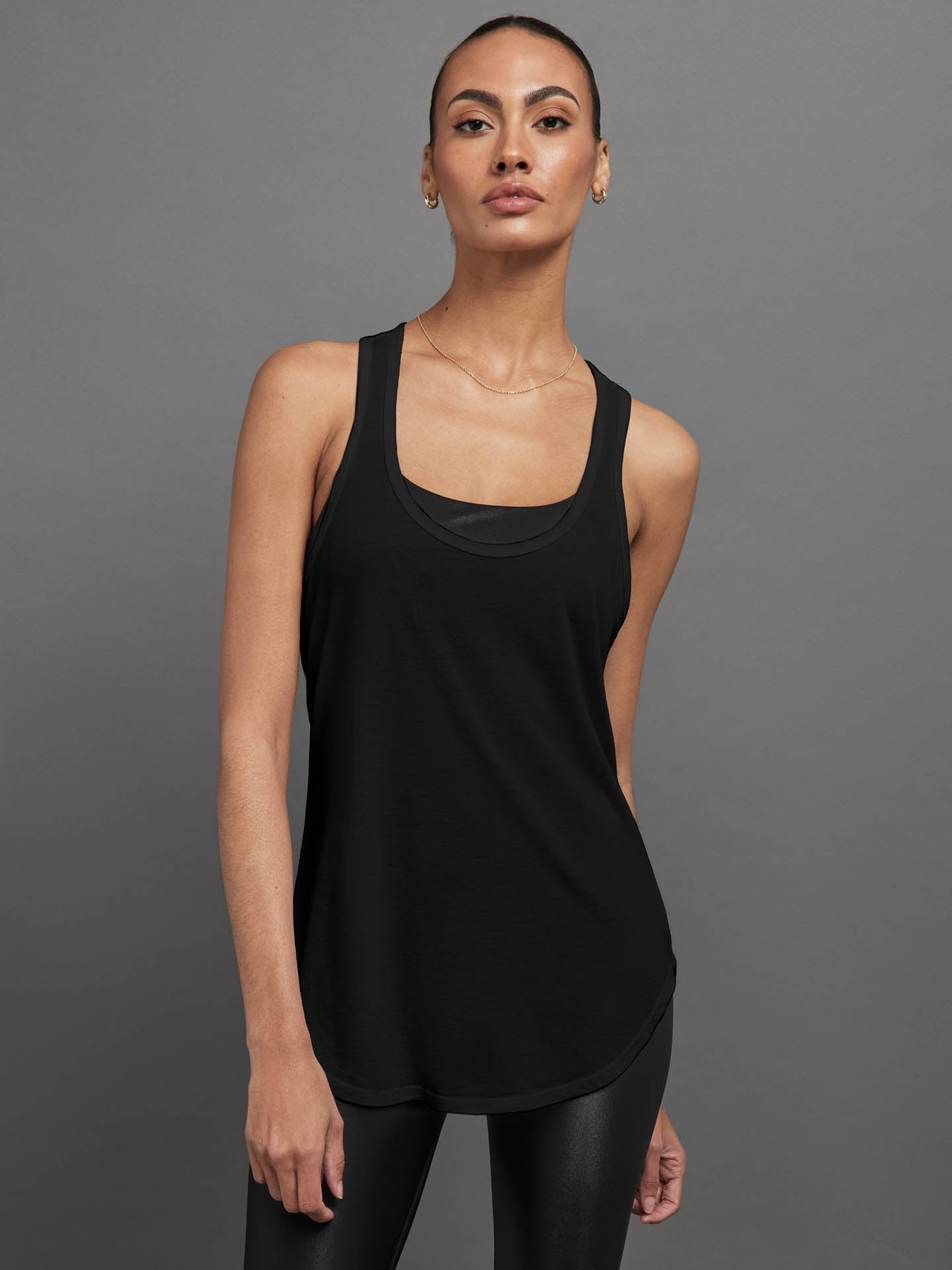 CARB-YD335-BLK-23SS-Long-RacerBack-Tank-color-Black_21 Model wears black long racerback tank top with a loose fit and scoop neckline.
