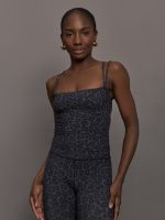 Model wears a tank top with double spaghetti straps in a dark gray leopard print.