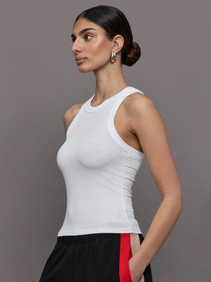 Model wears a white high neck ribbed jersey tank.