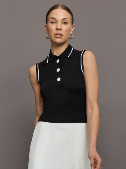 Model wears a sleeveless black tennis polo with three white buttons.