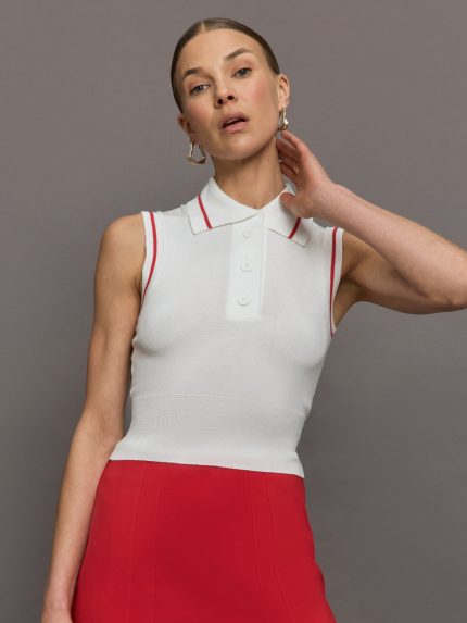 Model wears a sleeveless white tennis polo with three buttons and red seam detailing.