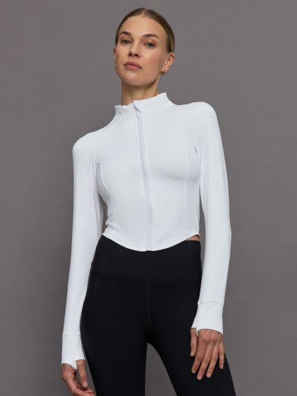 Model wearing a white mock neck corset zip top with thumb holes.