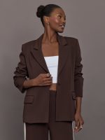 Model wearing brown single breasted blazer.
