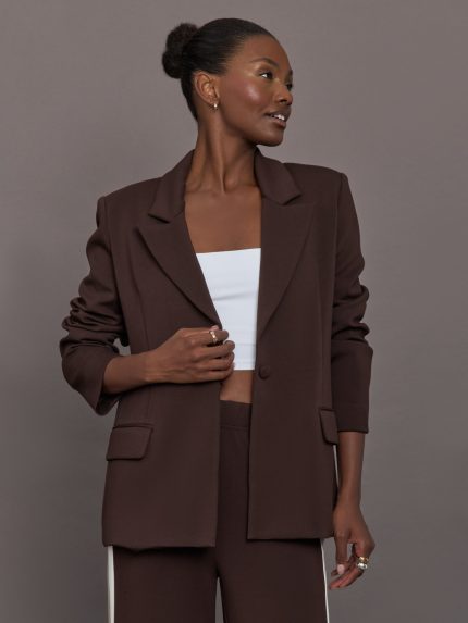 Model wearing brown single breasted blazer.