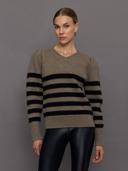 Model wears striped cream and black sweater with puffed sleeves and a relaxed fit.