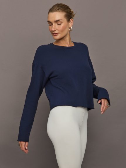 Model wears a navy crewneck sweatshirt.