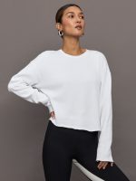 Model wears a white crew neck oversized french terry sweatshirt.