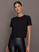 Model wears a cropped boxy black tee shirt.