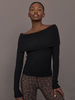 Model wearing a black off-shoulder sweater